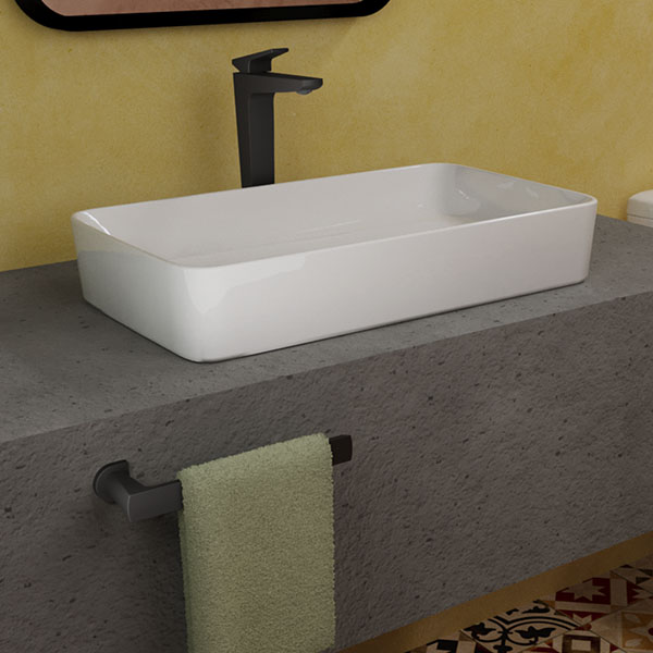 Monomando de lavabo en color negro de la colección Spiga en colores tierrosos y pared de fondo amarillo