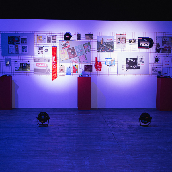 Stand del museo Helvex durante Encuentro Helvex 2025 con un recorrido por sus 75 años, en fondo blanco con iluminación azul neón